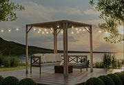 Cedar gazebo with outdoor furniture on a deck by a lake at sunset.